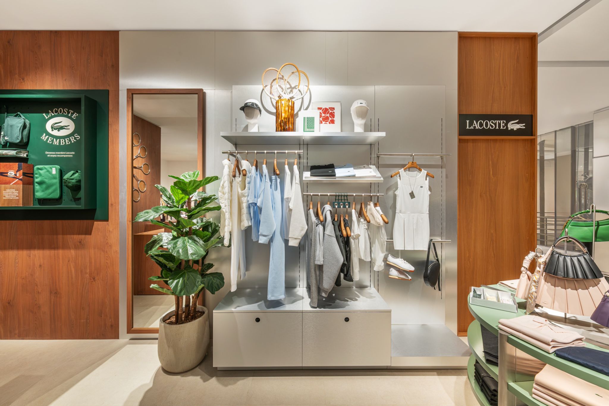 Éclairage d'un présentoir mural de vêtements et accessoires dans un corner de prêt-à-porter à Paris.