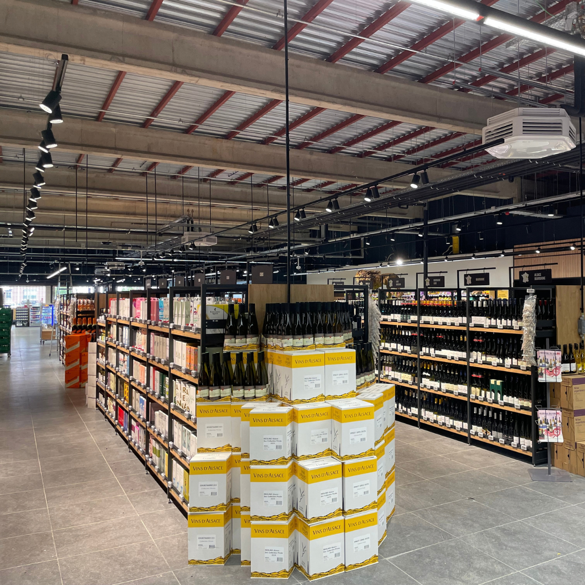 Éclairage de l’espace vins d’un magasin alimentaire à Amay