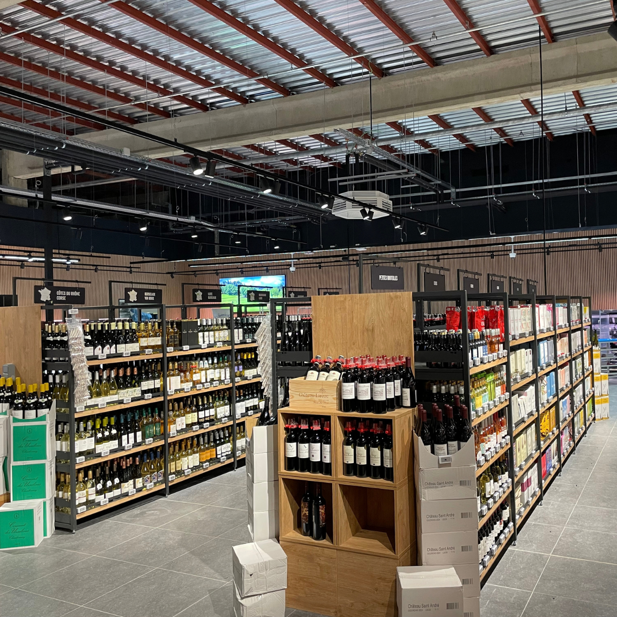 Éclairage des rayonnages de vins dans un commerce alimentaire à Amay